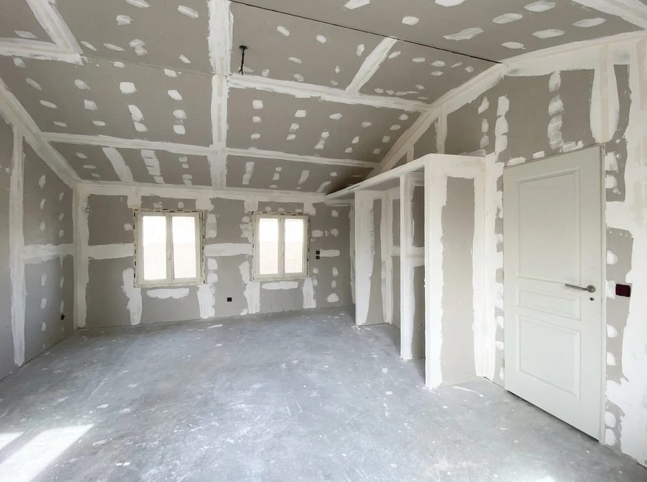 Pièce en cours de construction, murs et plafond en plaques de plâtre (BA13) avec joints et enduit de plâtre en cours de séchage
