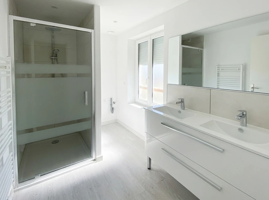 Salle de bains moderne, lumineuse, finition blanc laqué