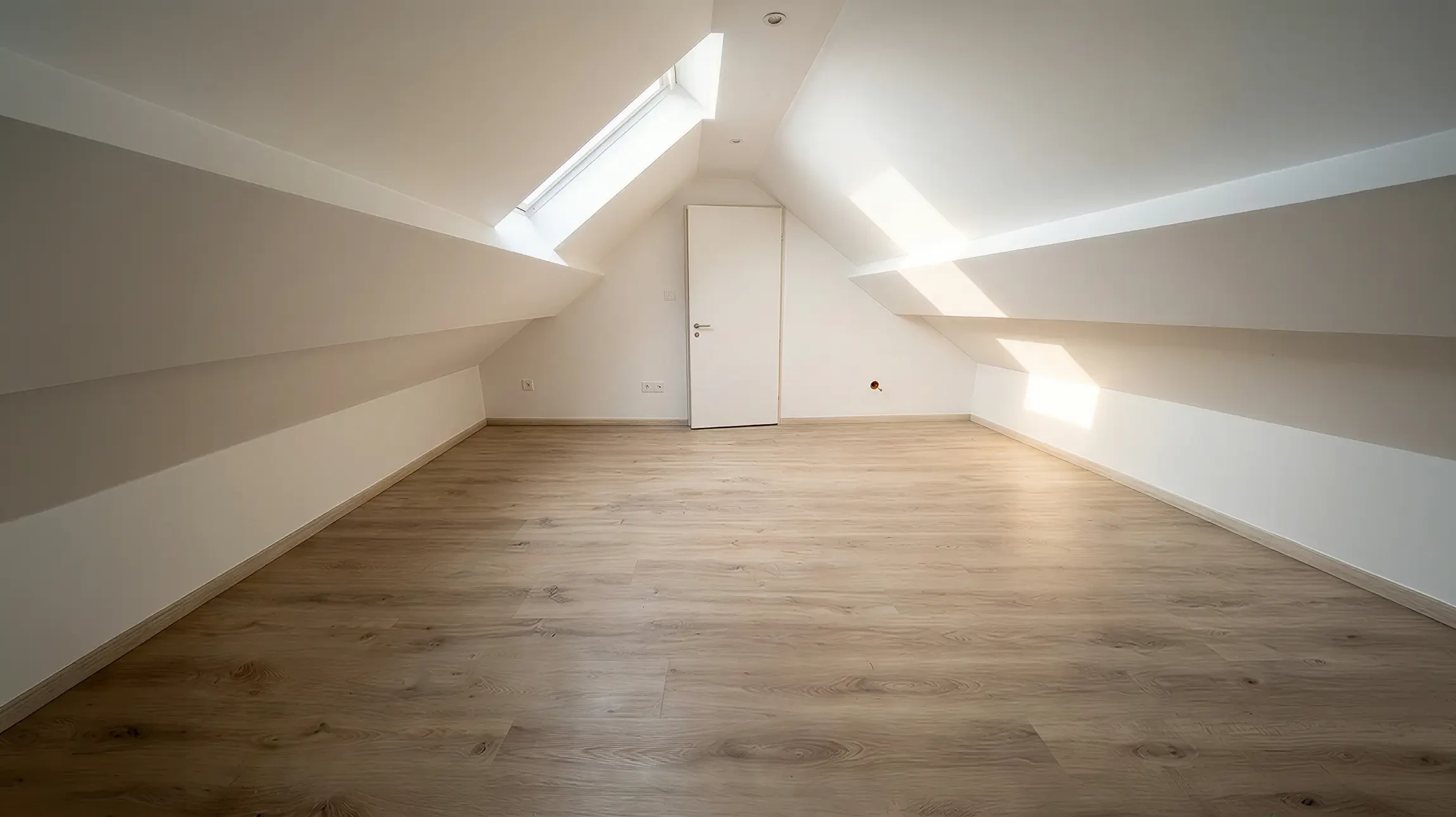 Une main tenant un couteau &agrave; enduire applique un enduit de lissage blanc sur un mur int&eacute;rieur, &agrave; la jonction entre une surface grise et blanche