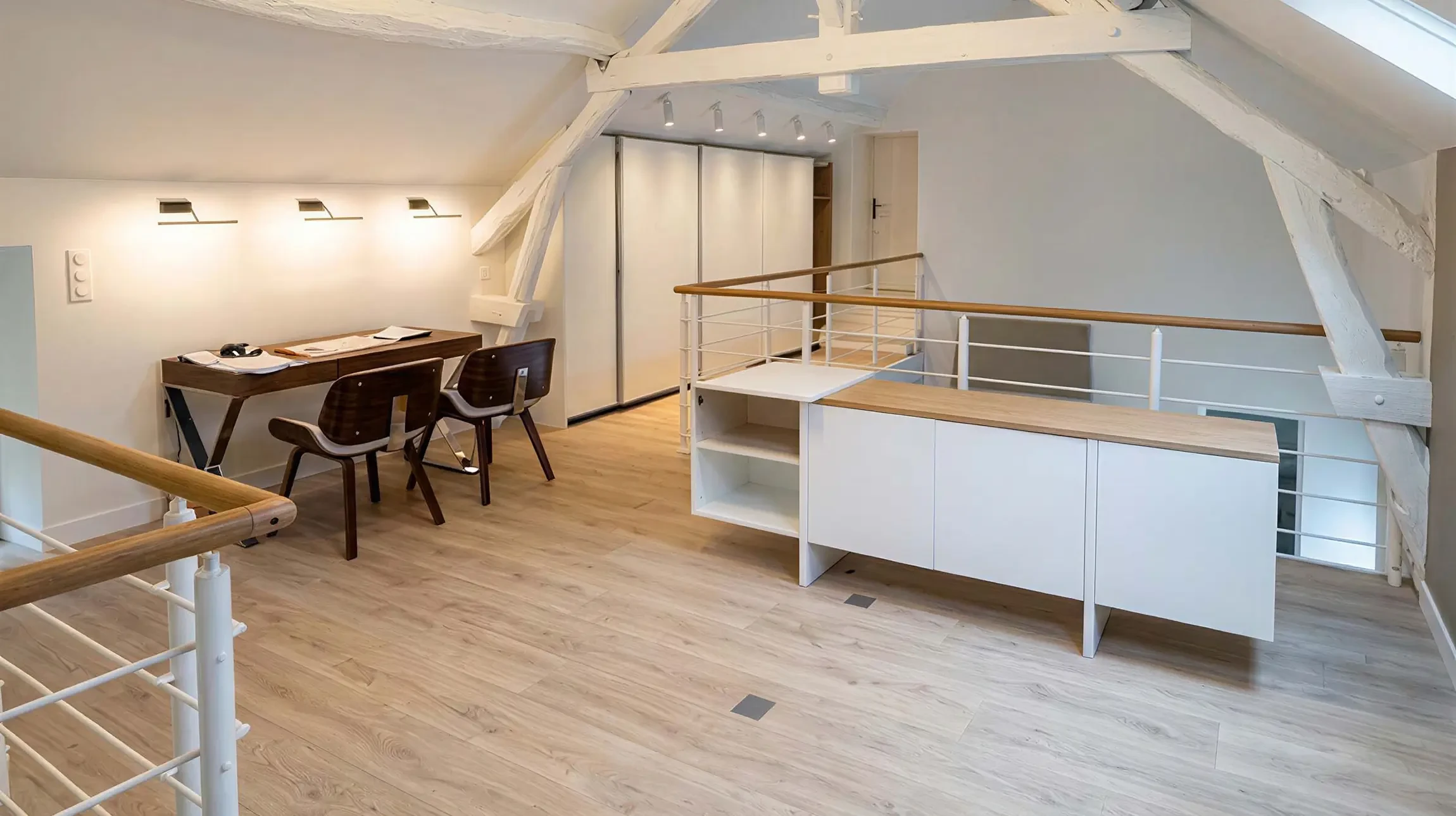 Artisan à genoux installe un parquet en lames de bois sur chantier intérieur
