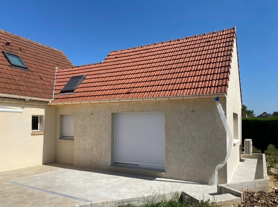 Deux maçons travaillent sur un chantier extérieur, posant des blocs de béton cellulaire